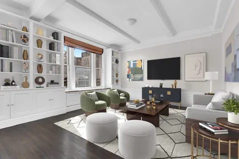 a living room with furniture a flat screen tv and a window