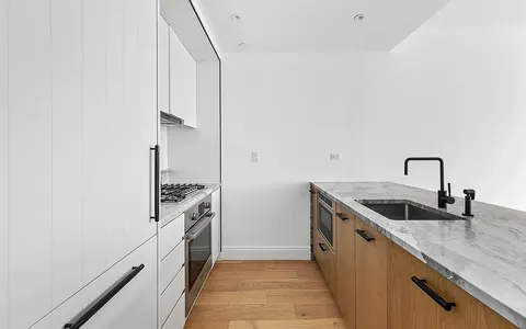 a kitchen with granite countertop a sink and stainless steel appliances
