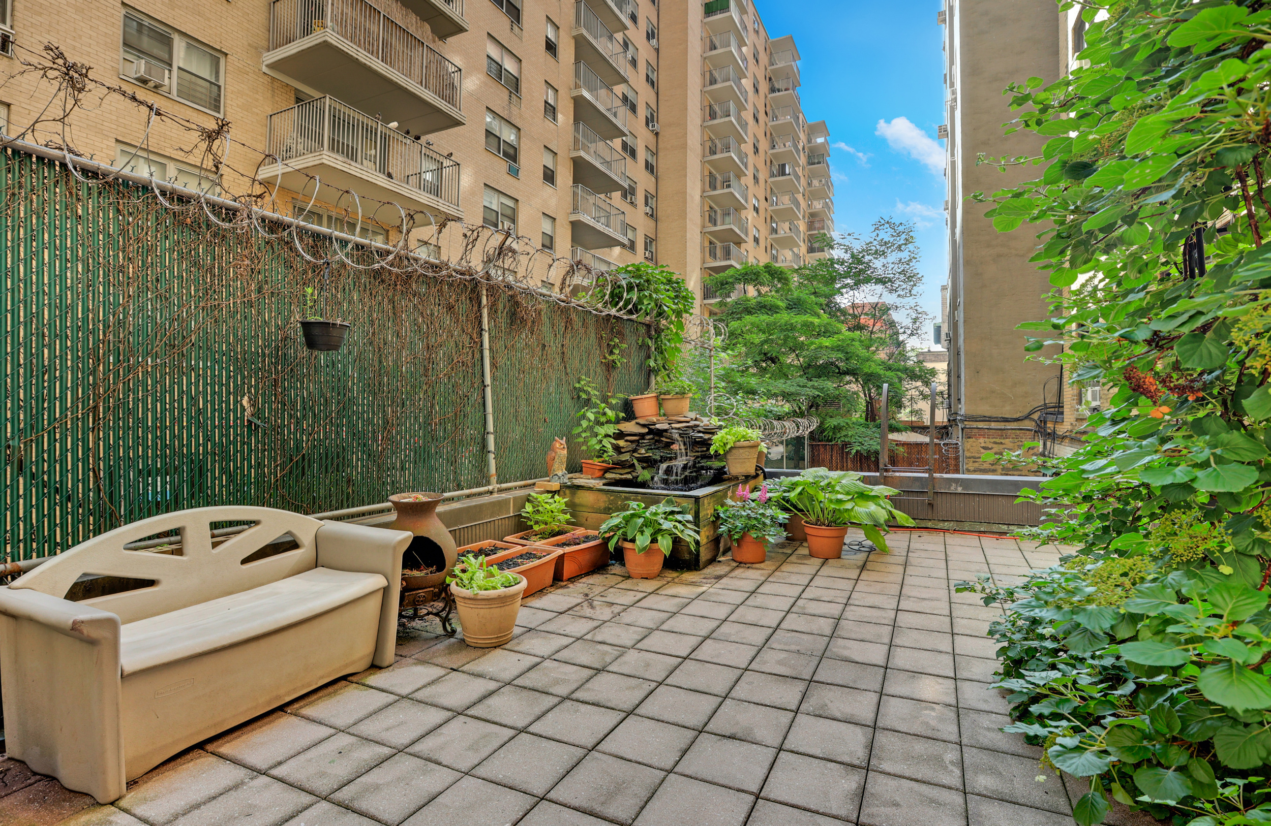 41 West 96th Street, Unit 1B Manhattan, NY 10025 - Photo 22 of 24 a backyard of a house with lots of green space and fountain