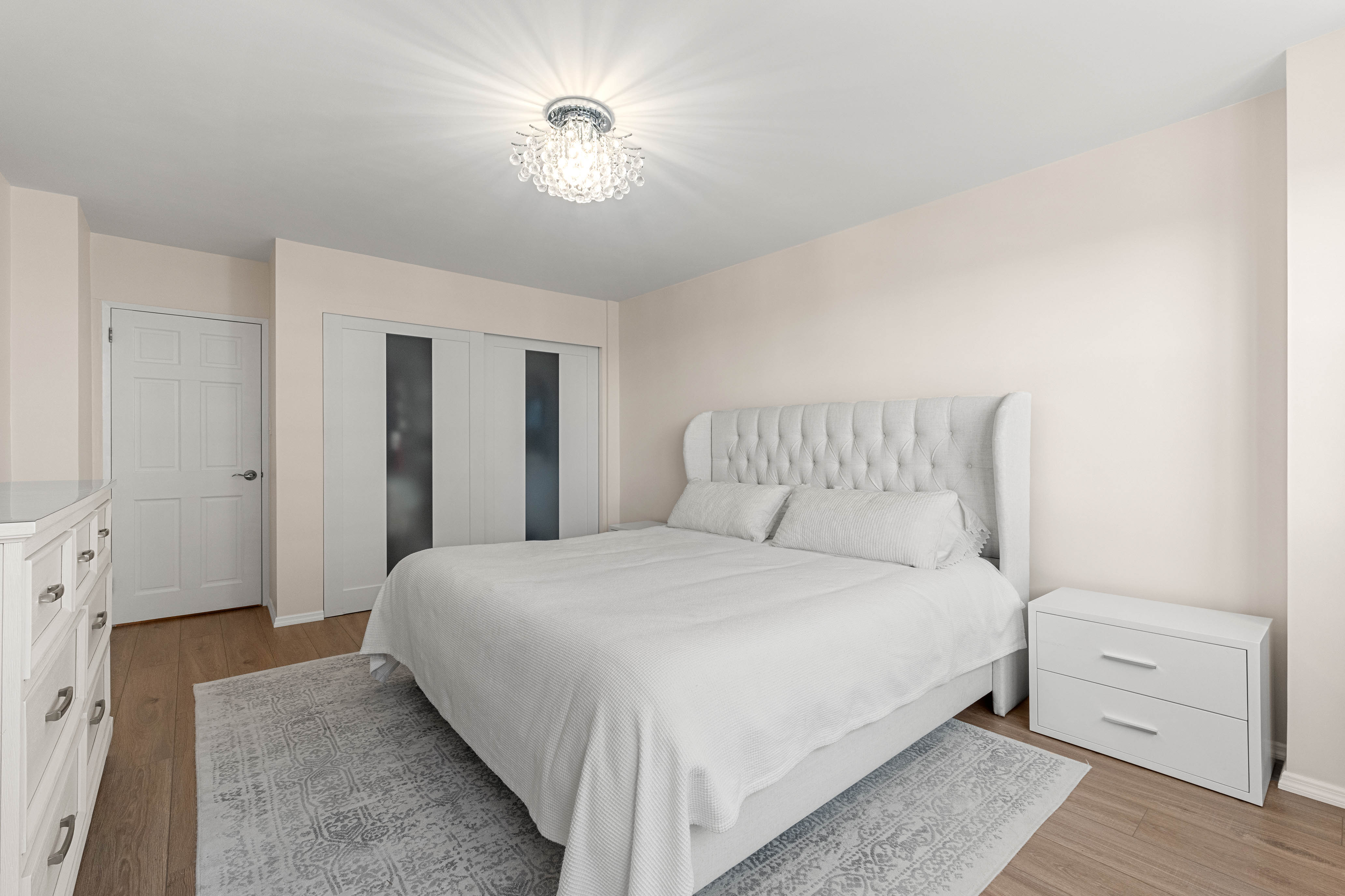 102-10 66th Road, Unit 21K Queens, NY 11375 - Photo 8 of 16 a bedroom with a bed and a chandelier