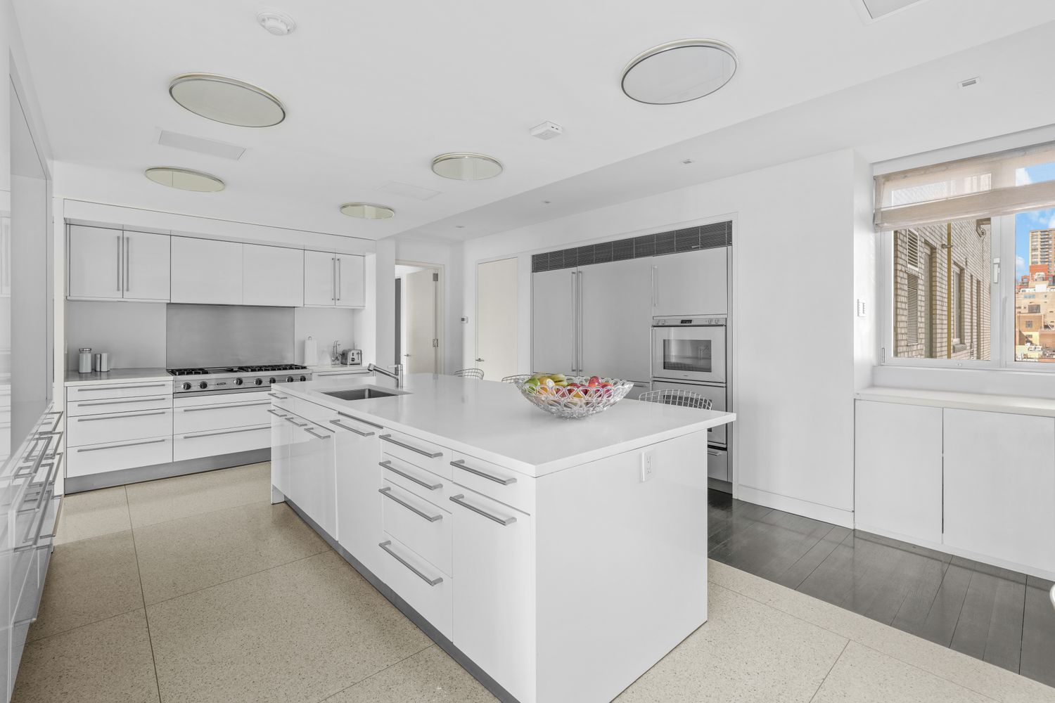 a kitchen with granite countertop a sink and white cabinets