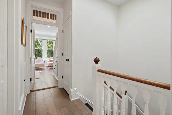 a view of a hallway with wooden floor and closet