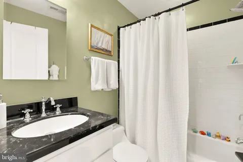 a bathroom with a sink vanity mirror and a toilet