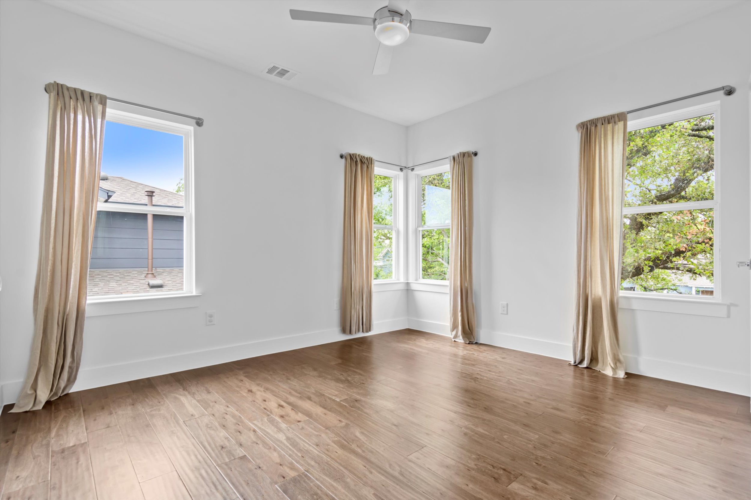 513 West Croslin Street, Unit A Austin, TX 78752 - Photo 23 of 39 a view of an empty room with a window and wooden floor