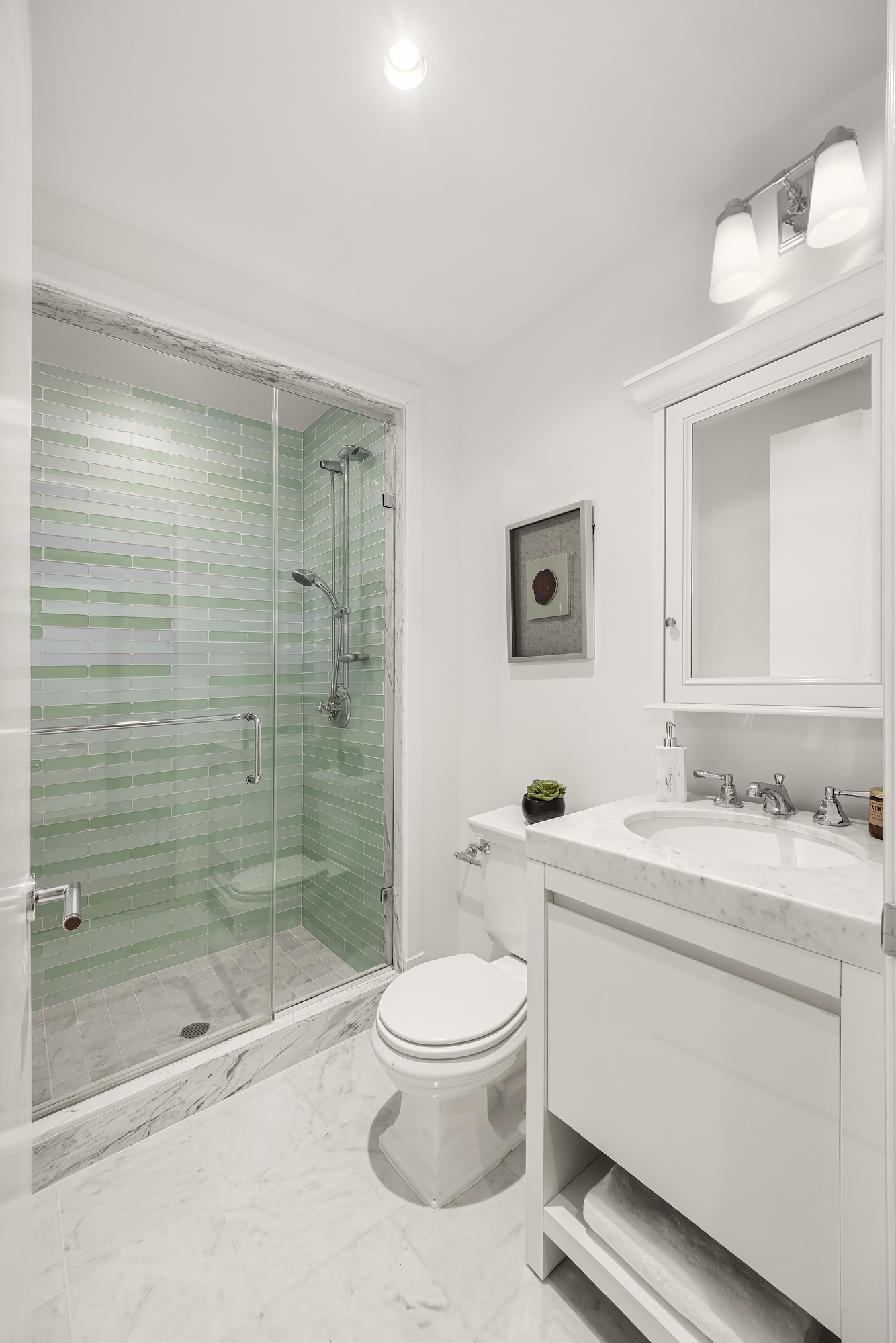 43 West 64th Street, Unit 7A Manhattan, NY 10023 - Photo 15 of 20 a bathroom with a bathtub shower sink mirror vanity and toilet