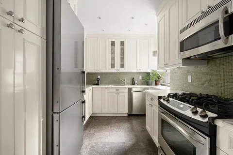 a kitchen with white cabinets and white appliances