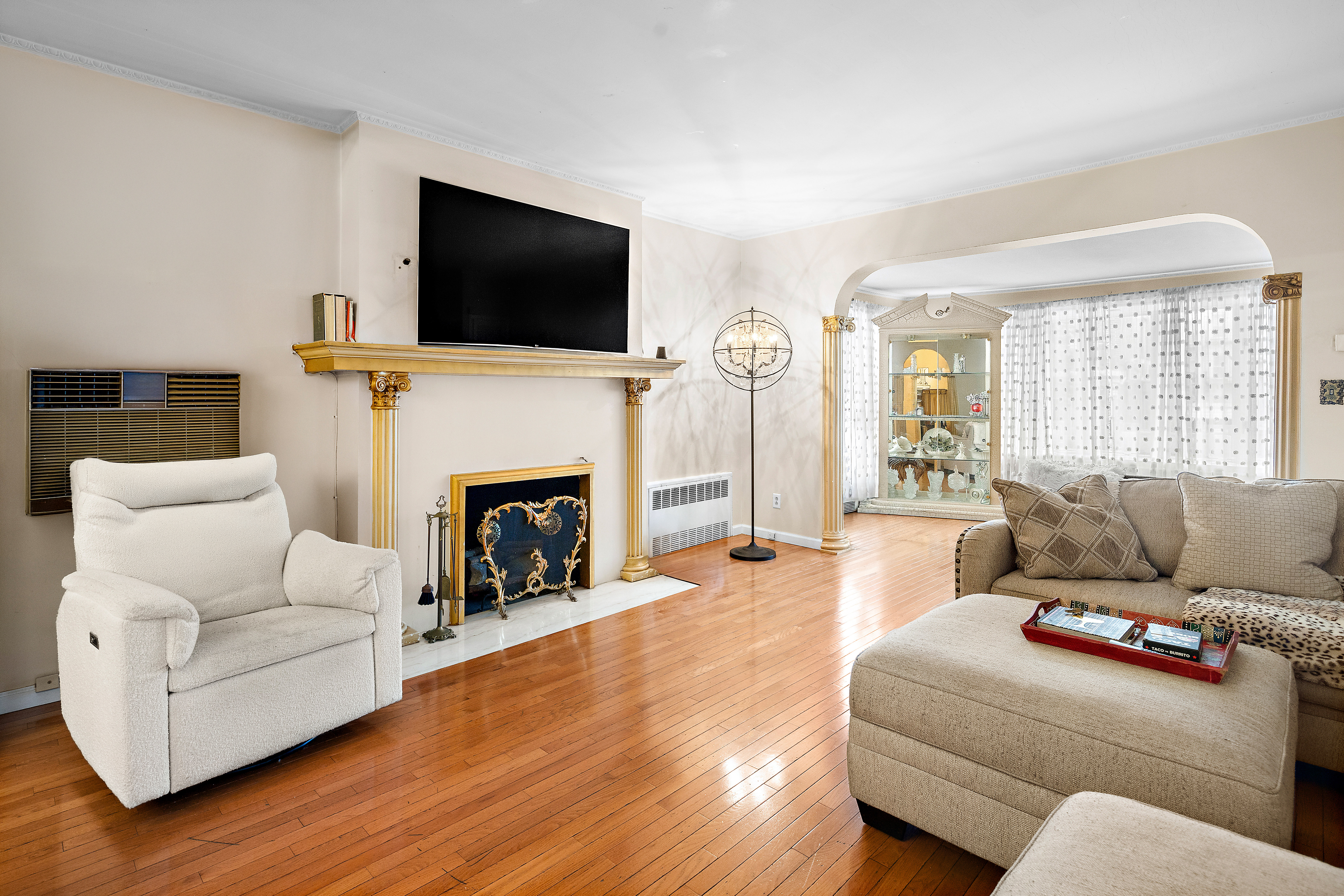 562 84th Street Brooklyn, NY 11209 - Photo 2 of 25 a living room with furniture a fireplace and a flat screen tv