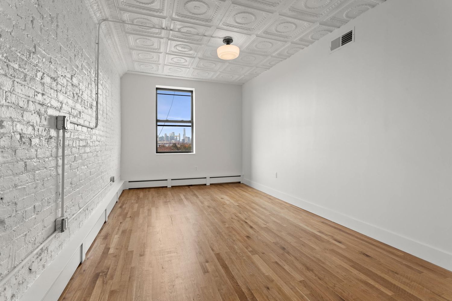 717 Manhattan Avenue, Unit 2A Brooklyn, NY 11222 - Photo 10 of 17 a view of a room with wooden floor and window