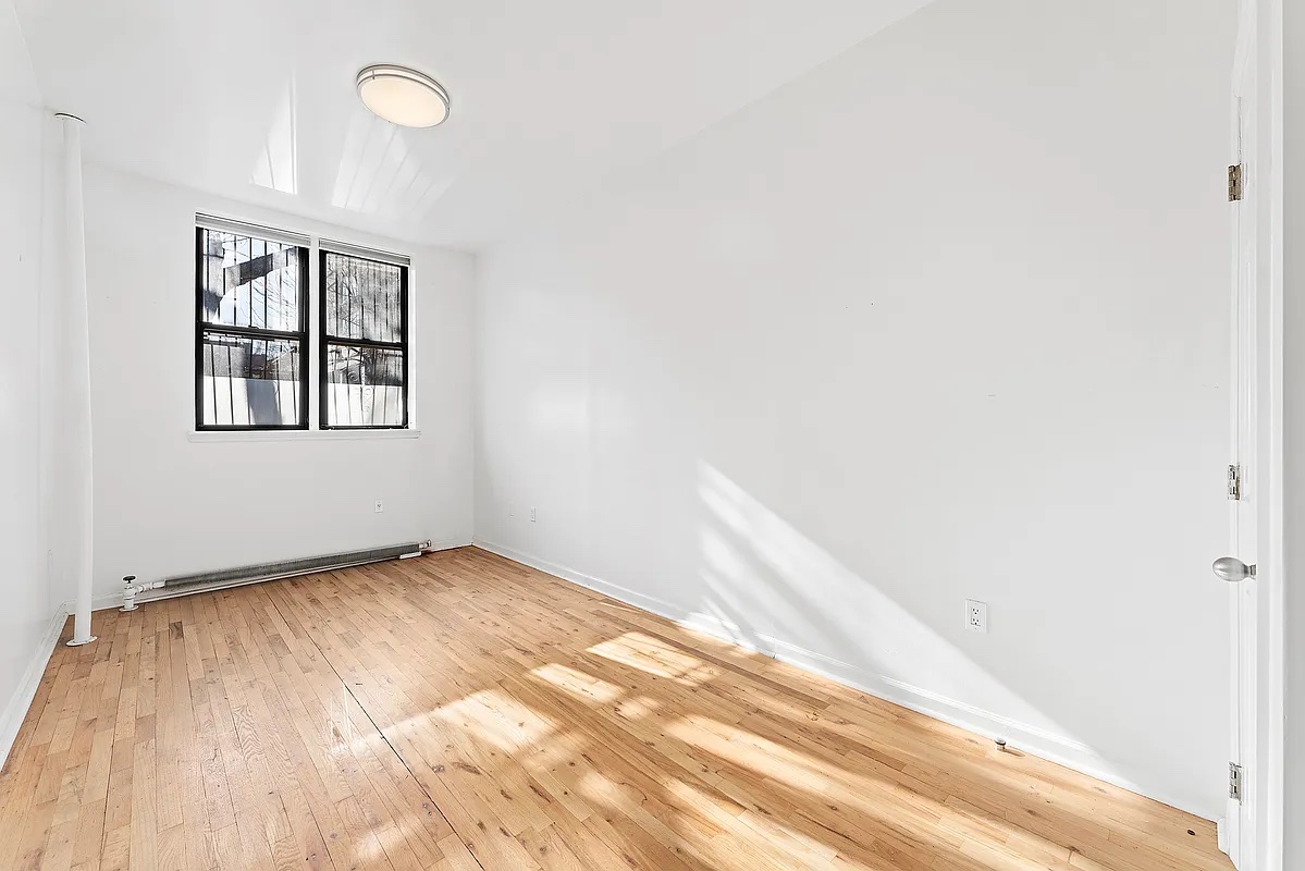115 South 8th Street, Unit 2 Brooklyn, NY 11249 - Photo 2 of 5 an empty room with wooden floor and windows