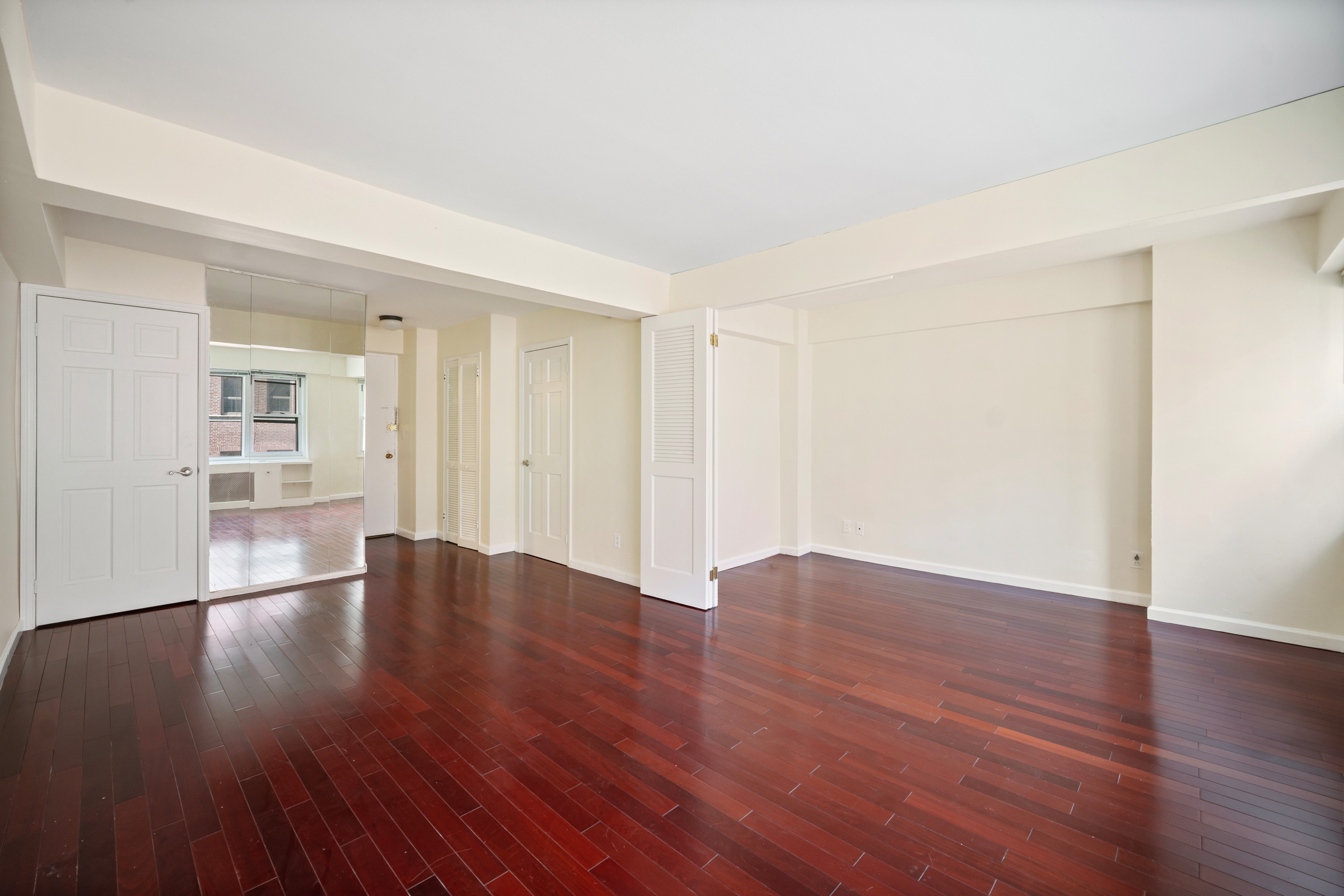 210 East 63rd Street, Unit 8C Manhattan, NY 10065 - Photo 3 of 12 a view of an empty room with wooden floor