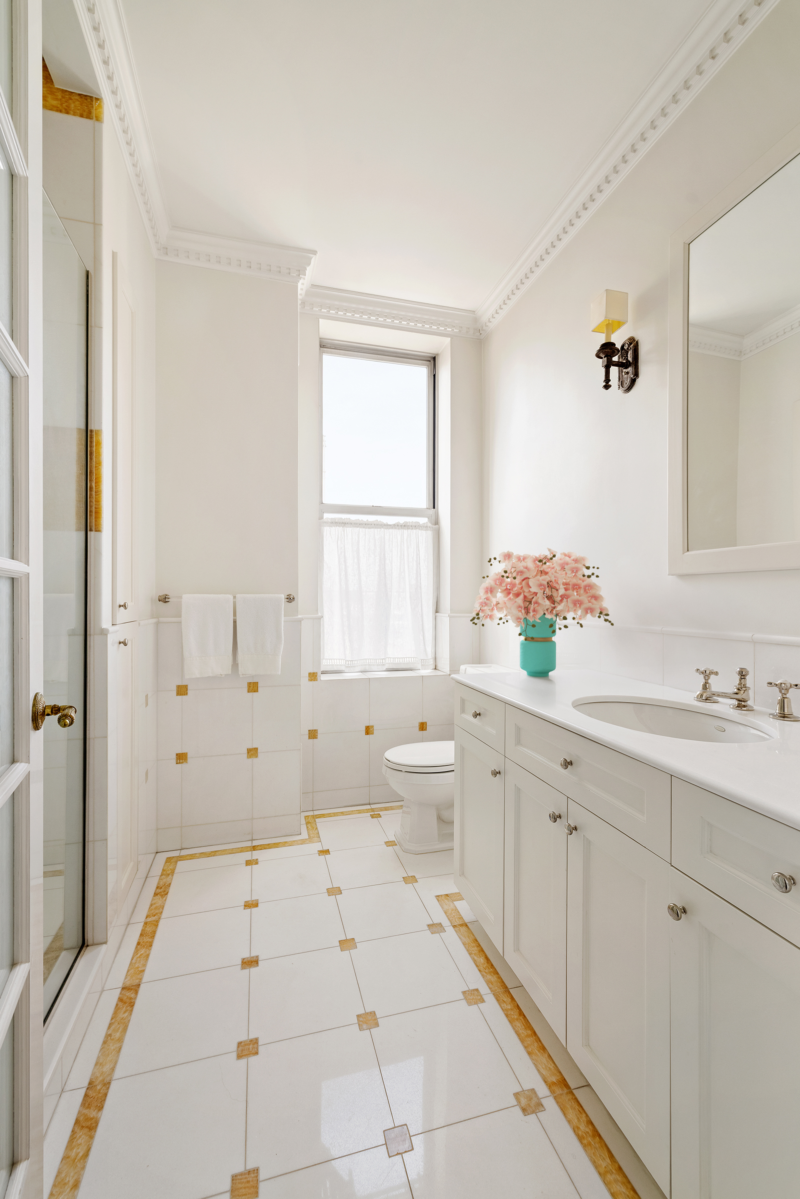 876 Park Avenue, Unit 9N Manhattan, NY 10075 - Photo 11 of 18 a spacious bathroom with a shower sink and mirror