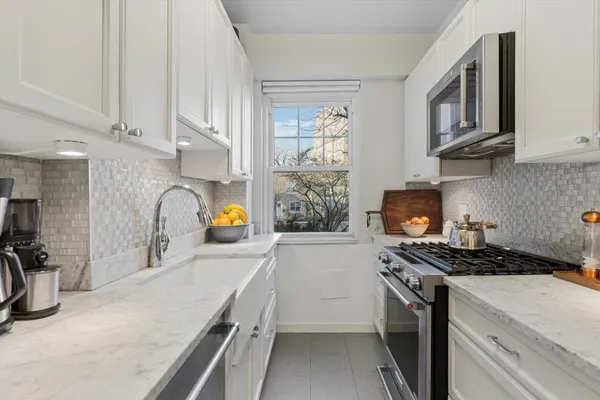 a kitchen with stainless steel appliances granite countertop a stove a sink and a refrigerator