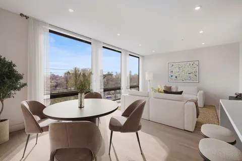 a dining room with furniture and a large window