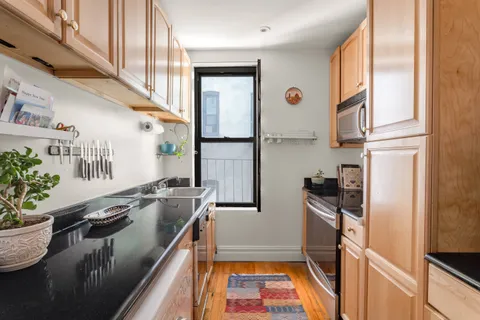 a kitchen with stainless steel appliances granite countertop a sink a stove and a refrigerator