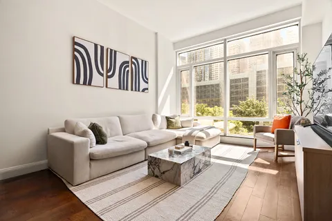 a living room with furniture and floor to ceiling windows
