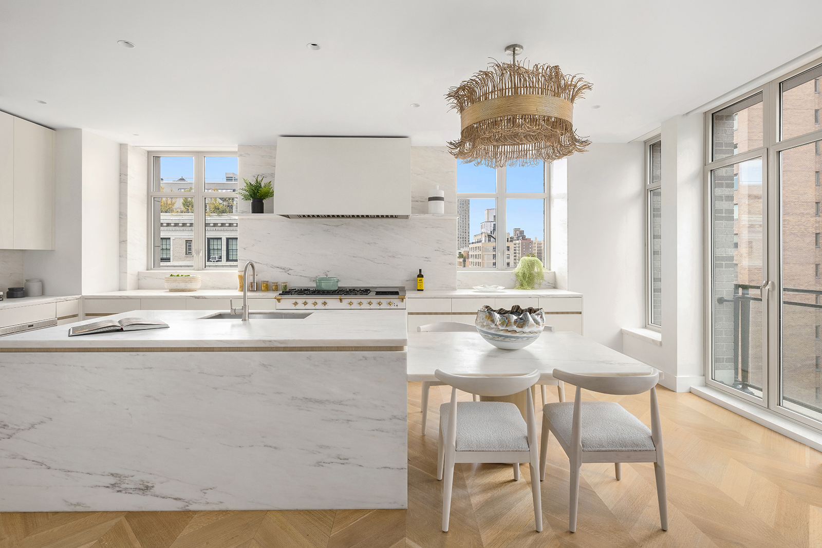 1228 Madison Avenue, Unit 10 Manhattan, NY 10128 - Photo 8 of 21 a kitchen with kitchen island granite countertop a table and chairs in it