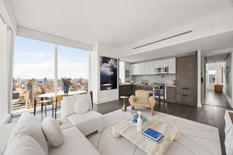 a living room with furniture kitchen view and large windows