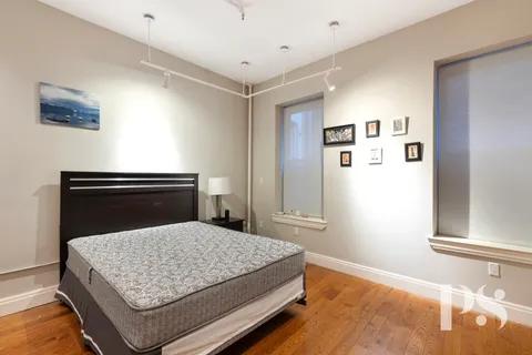 a bedroom with a bed and painting on the wall