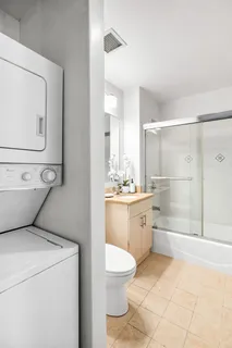 a bathroom with a granite countertop toilet sink and mirror