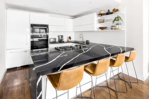 a room with stainless steel appliances kitchen island a stove and a refrigerator
