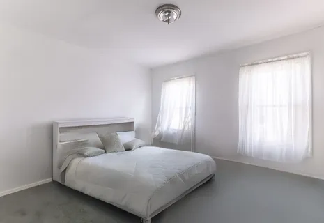 a bedroom with a bed and a window