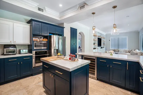 a kitchen with a stove a sink dishwasher a refrigerator and a oven with wooden cabinets