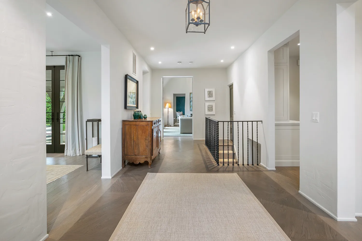 a view of a hallway with wooden floor and windows