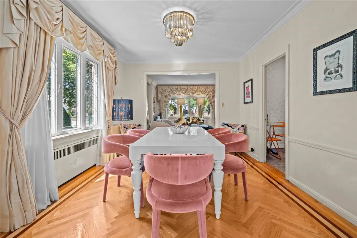 a view of a dining room with furniture a chandelier and wooden floor
