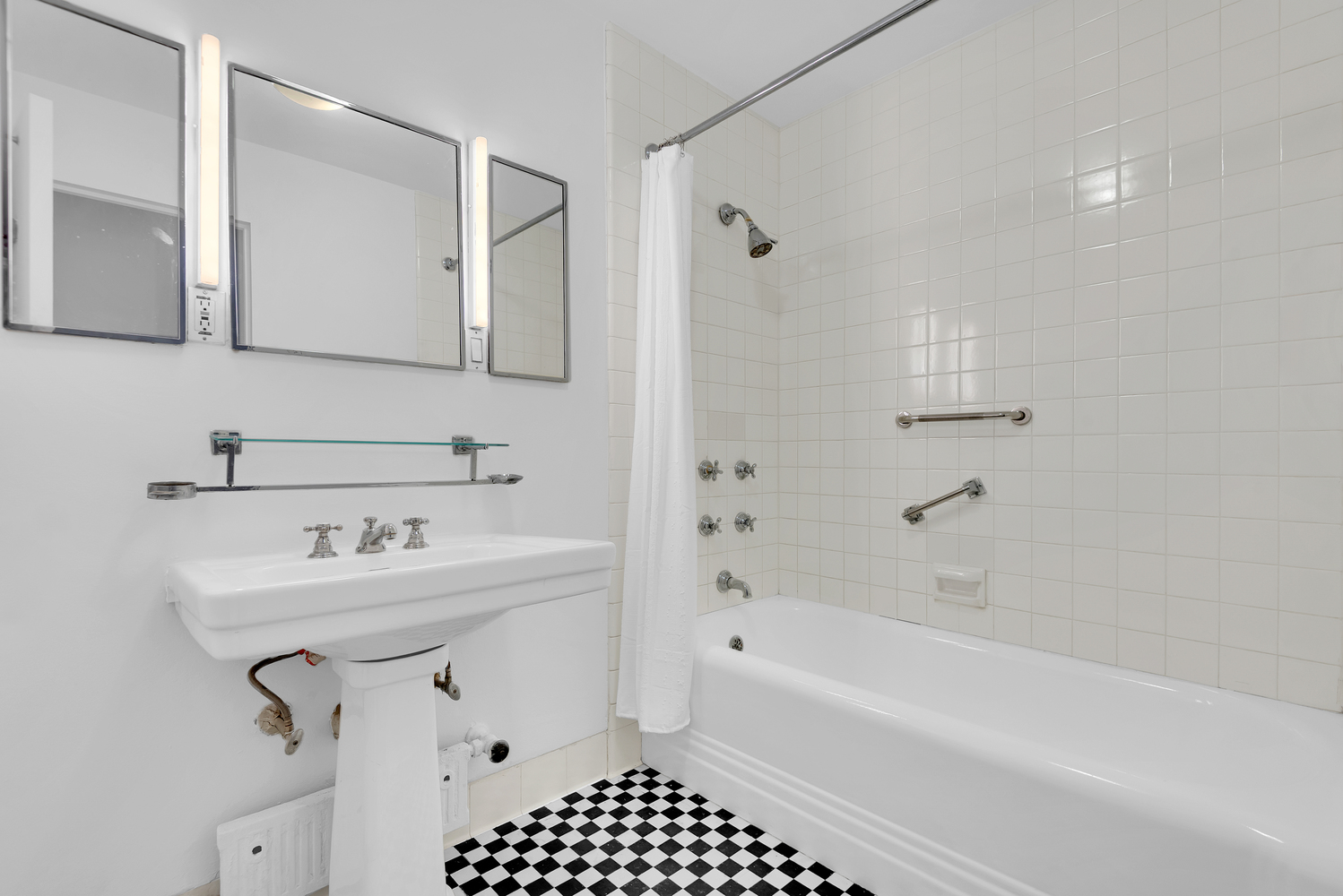 24 West 55th Street, Unit 3D Manhattan, NY 10019 - Photo 7 of 10 a bathroom with a sink a toilet and shower