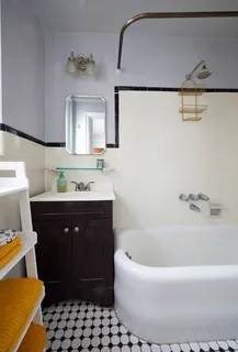 a bathroom with a bathtub sink and mirror