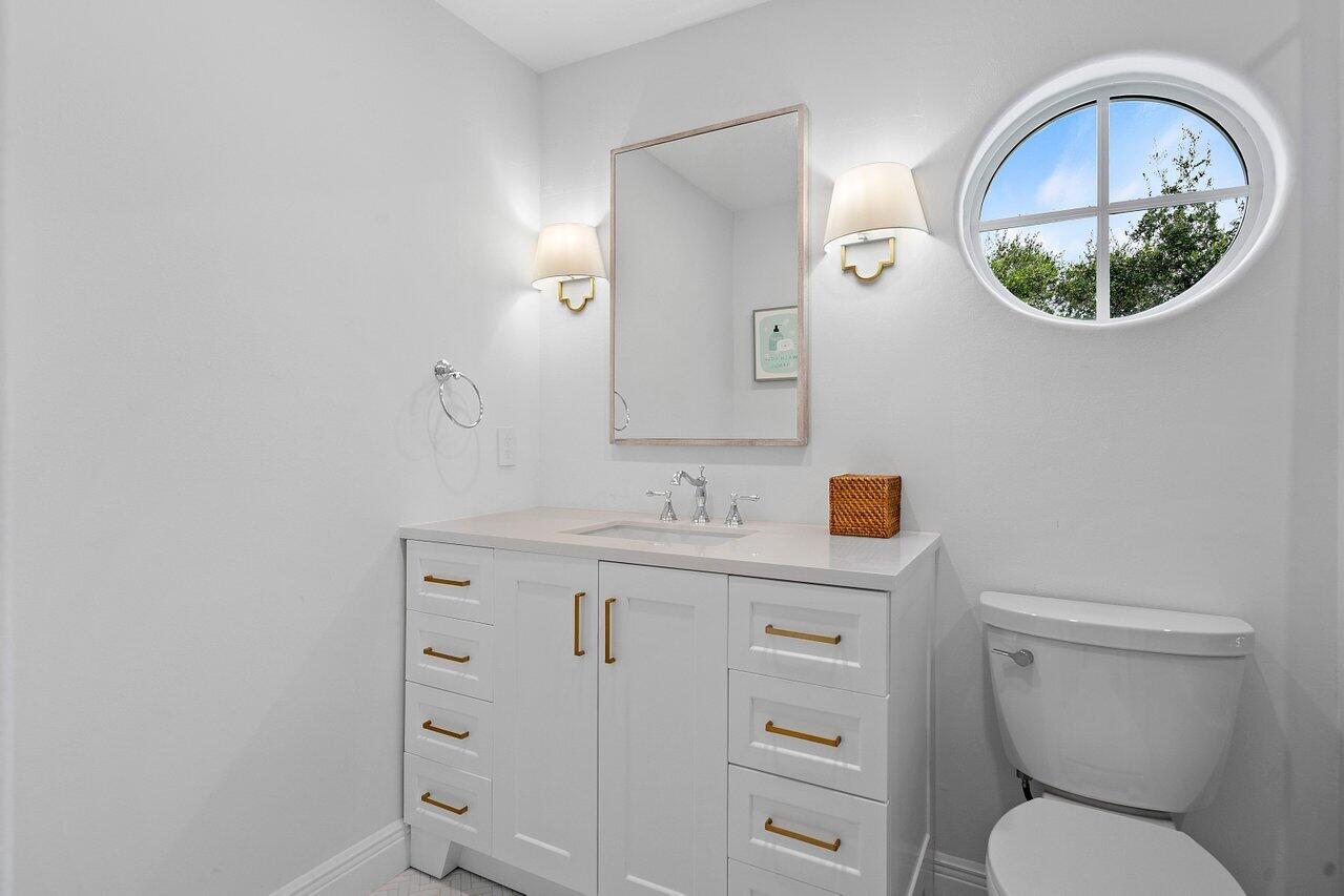1182 Canoe Point Delray Beach, FL 33444 - Photo 26 of 46 a bathroom with a toilet sink vanity and mirror