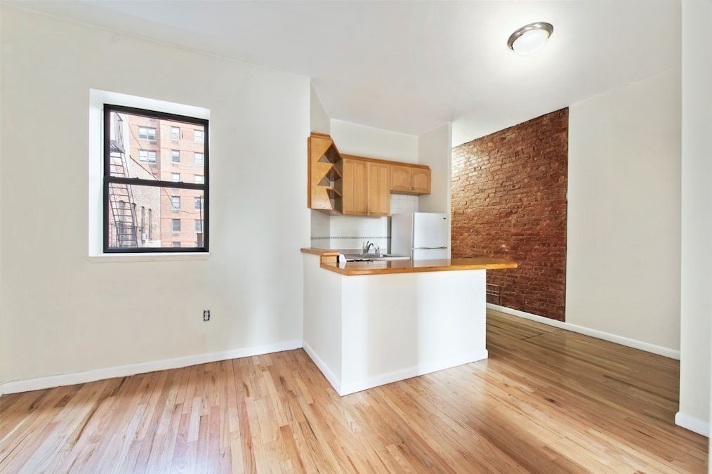 309 East 95th Street, Unit 27 Manhattan, NY 10128 - Photo 2 of 8 a view of kitchen with wooden floor and window