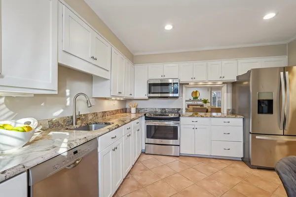 a kitchen with white cabinets and white appliances