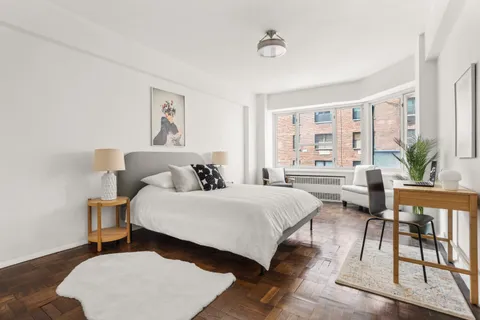 a spacious bedroom with a bed a table and chair