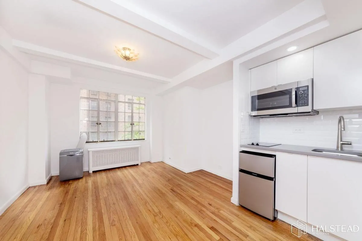 a kitchen with granite countertop a stove a sink and a microwave