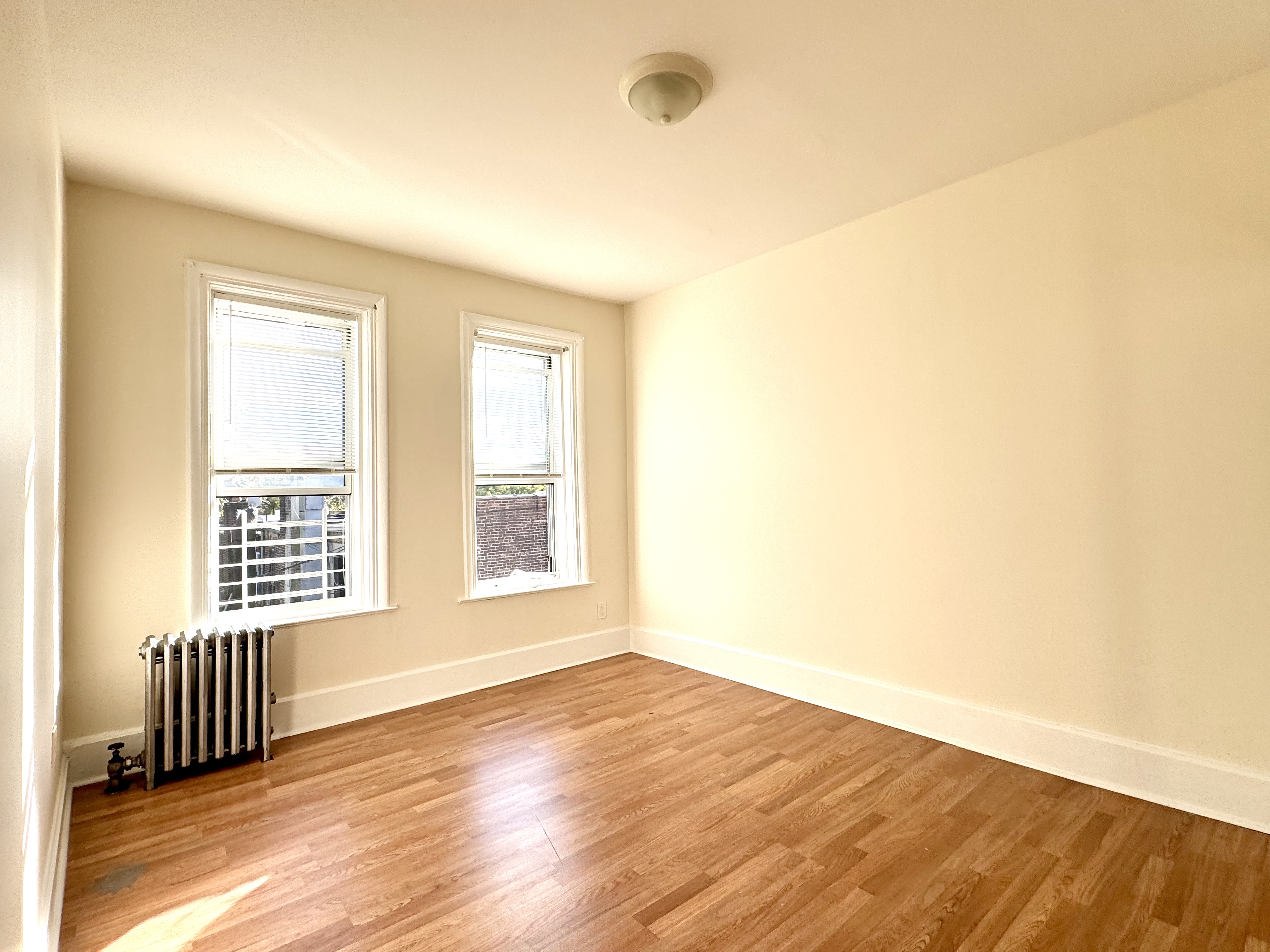 1688 Carroll Street, Unit 2 Brooklyn, NY 11213 - Photo 6 of 9 a view of an empty room with wooden floor and a window