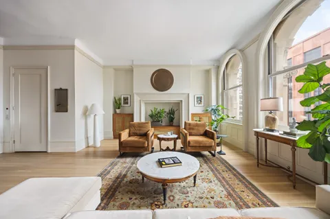 a living room with furniture a window and wooden floor