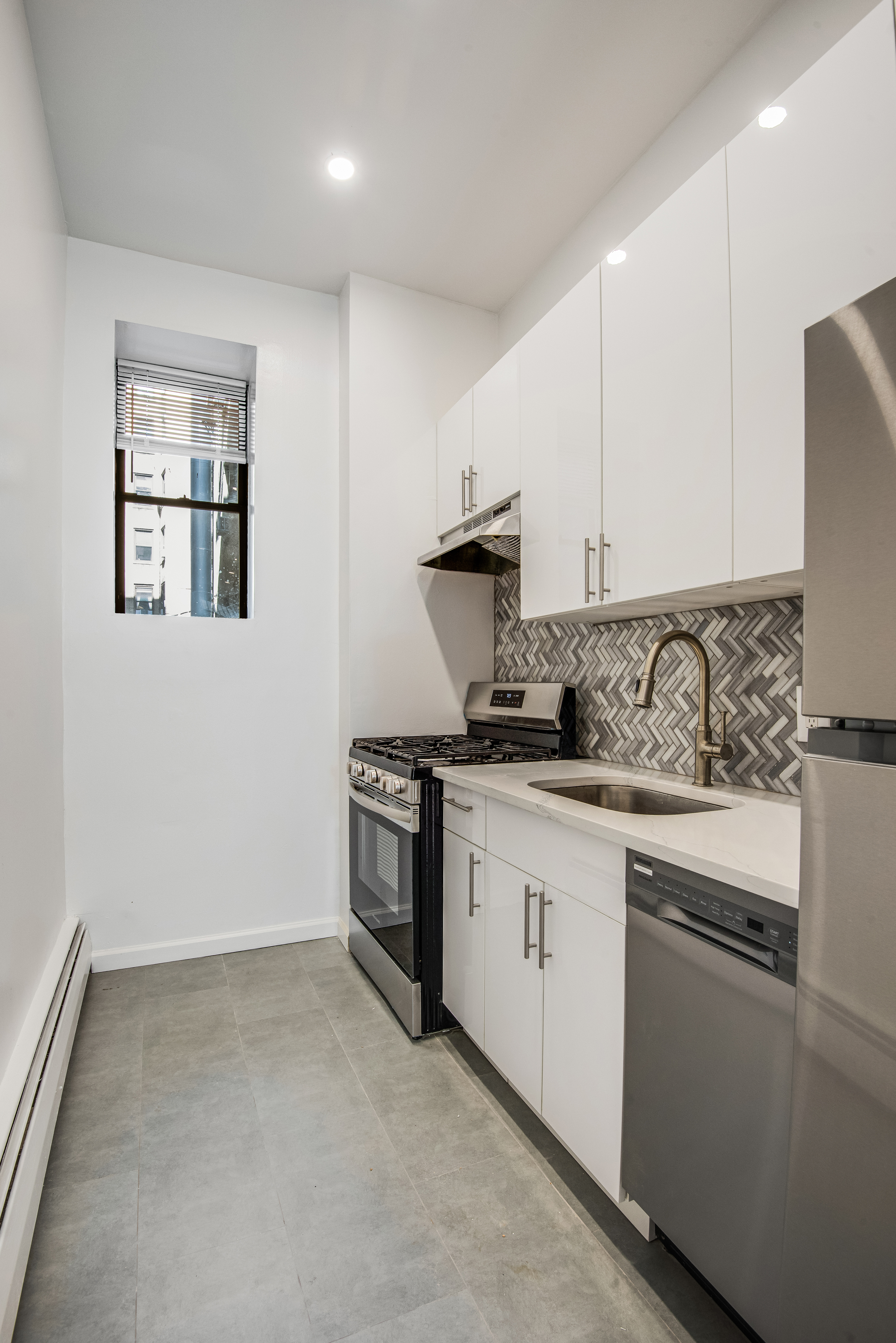 182 East 2nd Street, Unit 1E Manhattan, NY 10009 - Photo 8 of 14 a kitchen with granite countertop white cabinets and stainless steel appliances