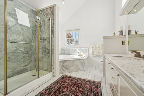 a bathroom with a granite countertop sink a toilet and shower