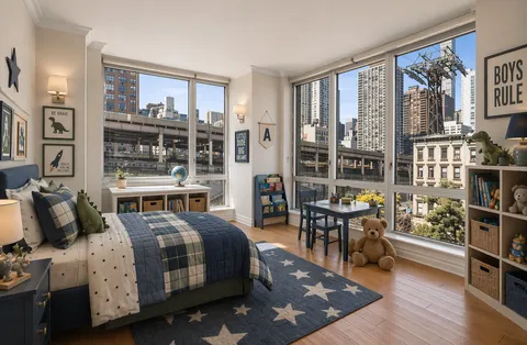a bedroom with a bed a large window and book shelf