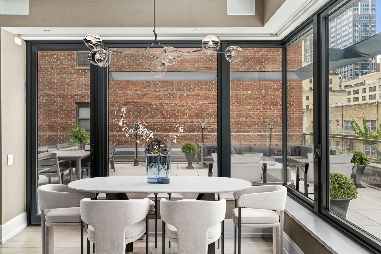 a dining room with furniture a chandelier and glass door