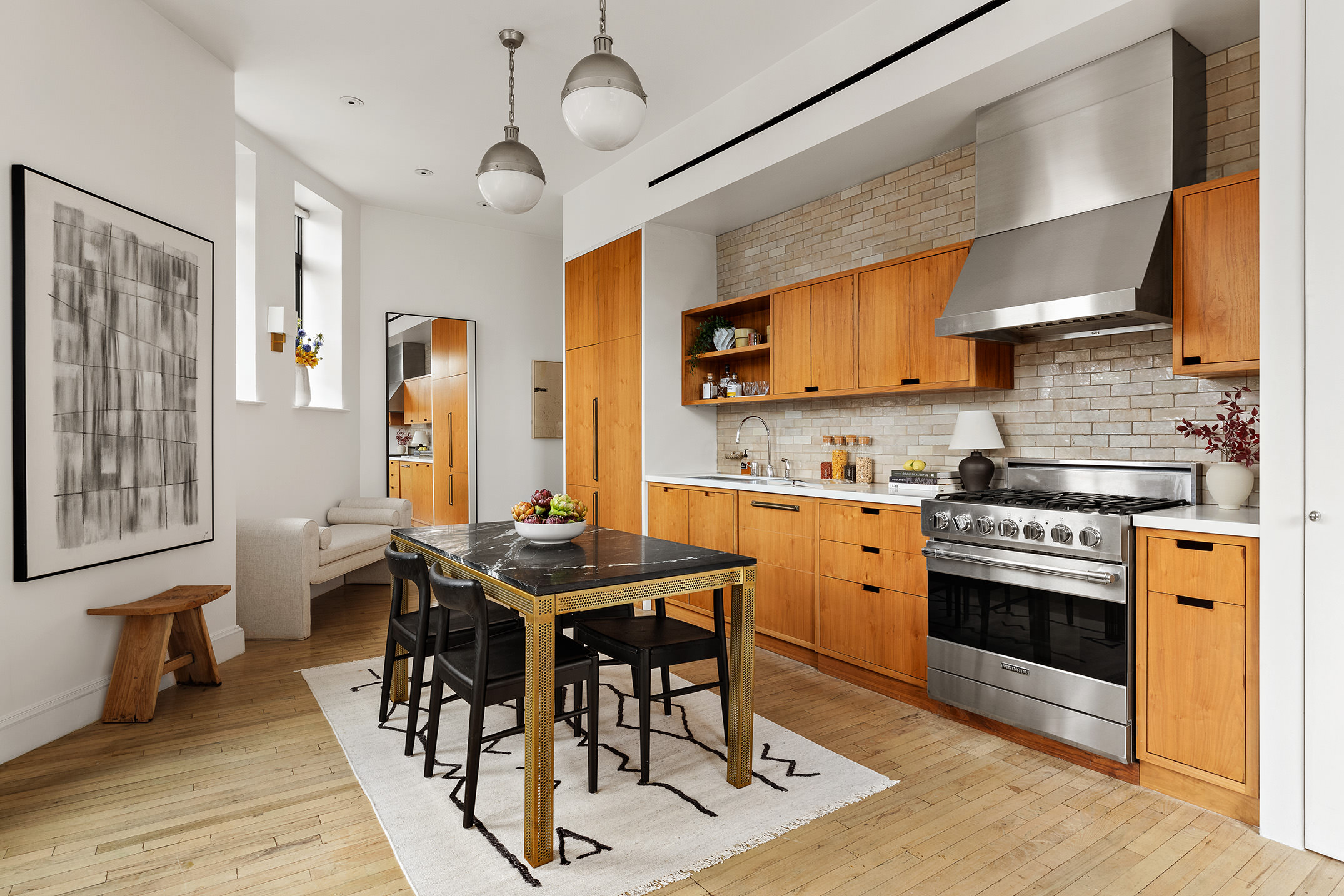 2 Cornelia Street, Unit 506 Manhattan, NY 10014 - Photo 2 of 11 a kitchen with stainless steel appliances granite countertop a stove a refrigerator a sink dishwasher a dining table and chairs with wooden floor
