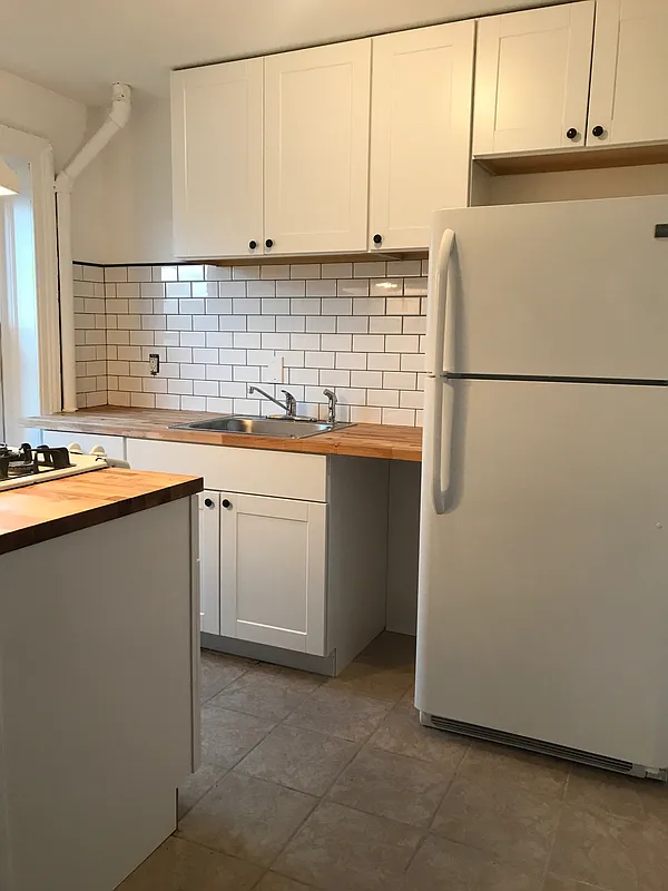 1379 Pacific Street, Unit 4 Brooklyn, NY 11216 - Photo 5 of 8 a kitchen with stainless steel appliances granite countertop a sink stove and refrigerator