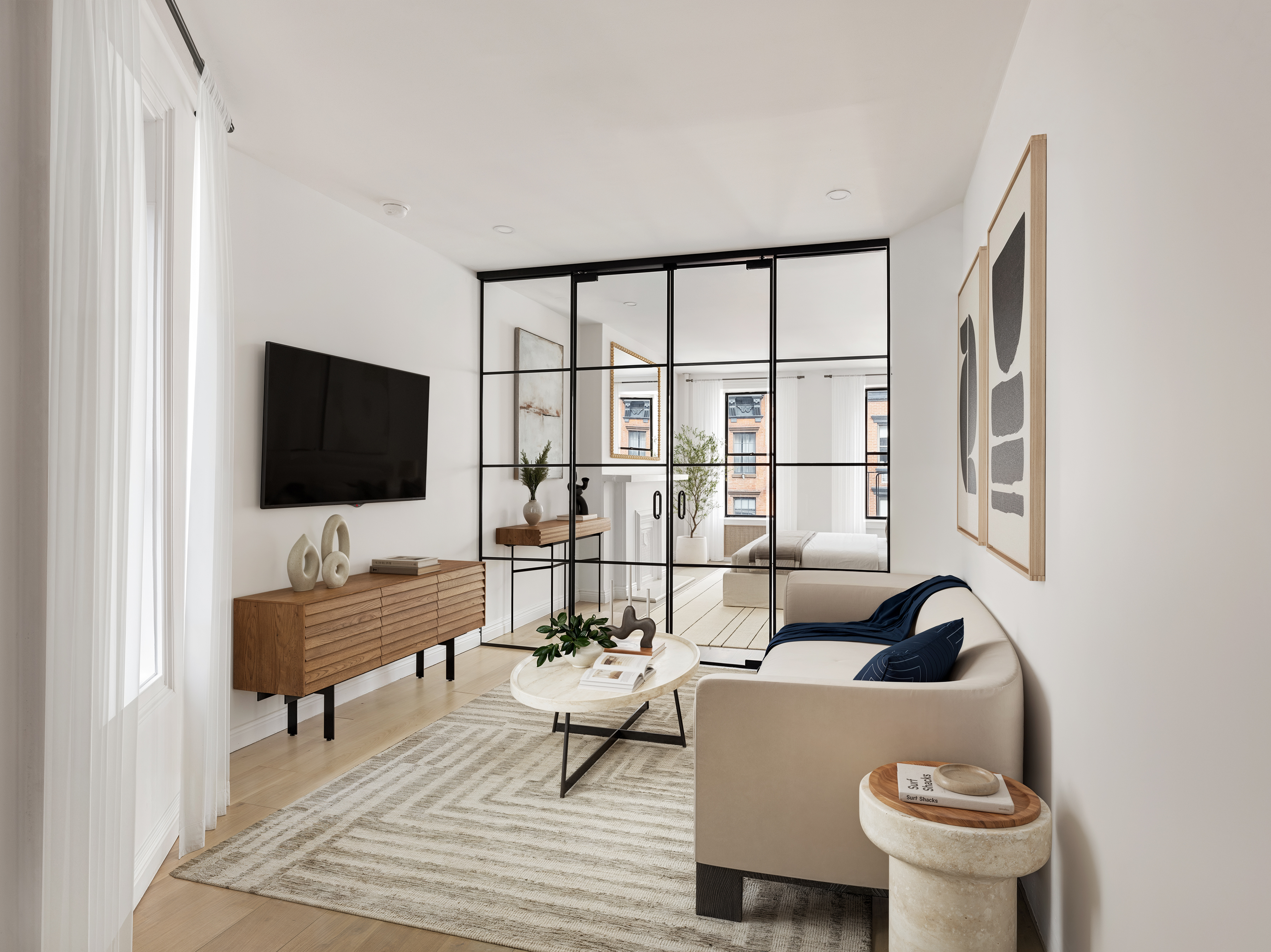 a living room with furniture a flat screen tv and a window