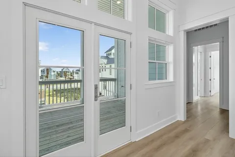 a view of empty room with wooden floor and window