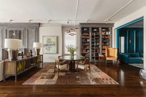 a living room with furniture and a dining table with rug