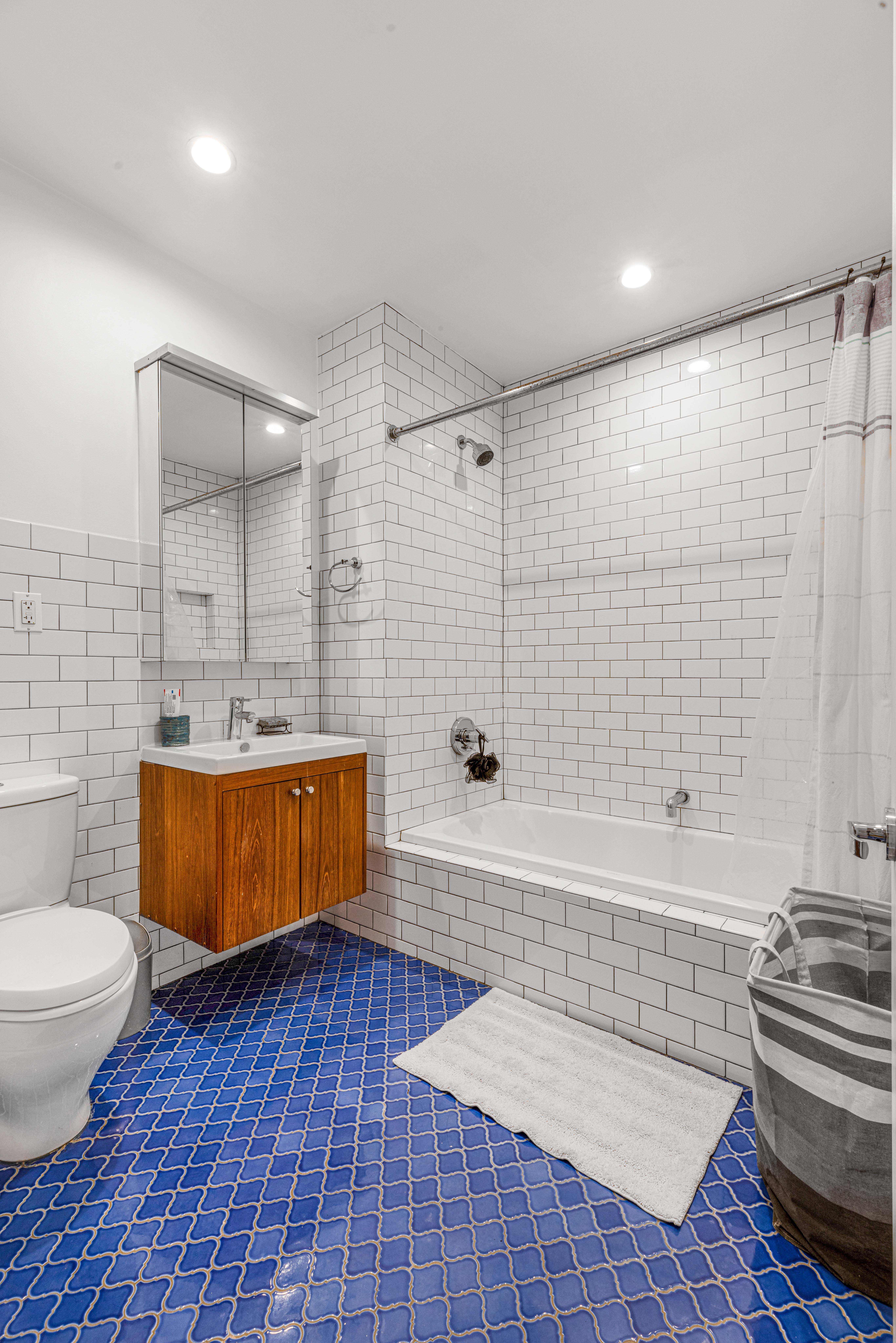 209 Calyer Street, Unit 2 Brooklyn, NY 11222 - Photo 15 of 17 a bathroom with a sink a toilet a mirror a bathtub and shower