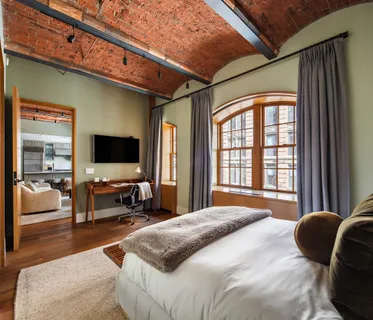 a bedroom with a bed and a flat tv screen next to a window