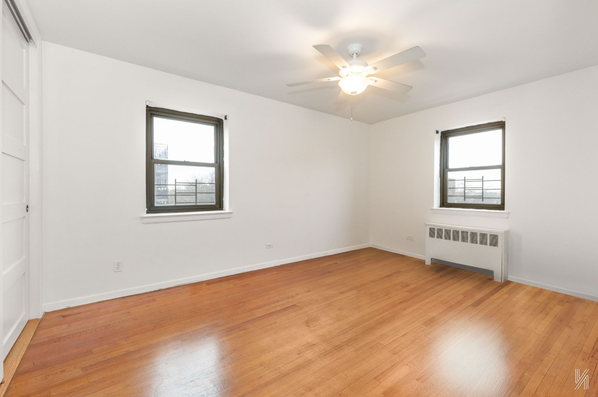 34-10 94th Street, Unit 6G Queens, NY 11372 - Photo 5 of 19 a view of an empty room with chandelier fan and a window