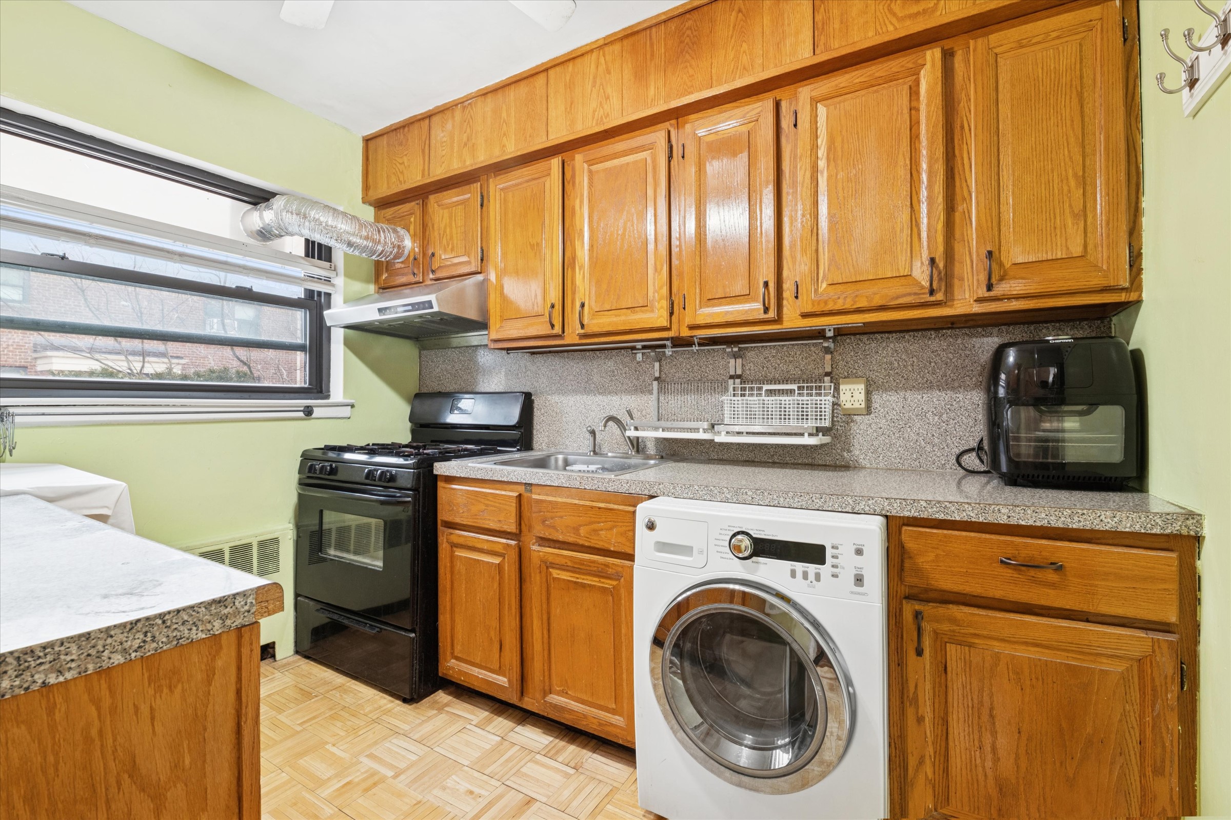 74-22 220th Street Oakland Garden, NY 11364 - Photo 13 of 16 a kitchen with stainless steel appliances granite countertop a sink a stove and cabinets